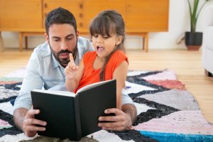 Girl reading to father