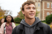youth classmates looking out to the horizon with their school behind them 