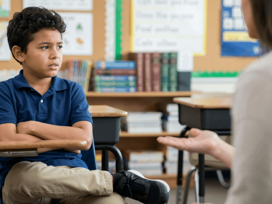 child struggling at school talking to his teacher